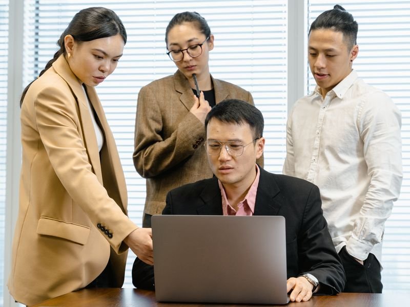 Team gathered around a laptop in a bright office