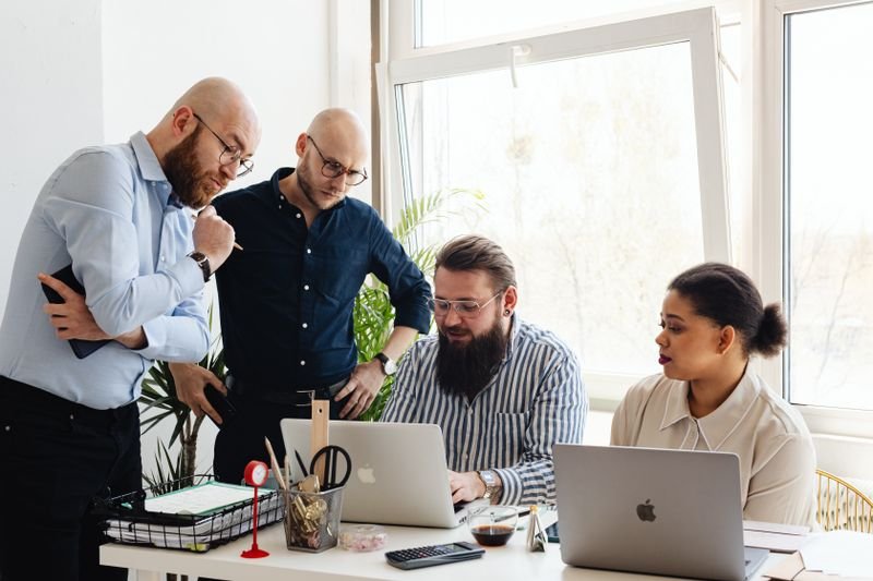 Team gathered around laptops in a bright office