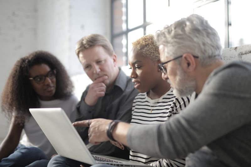 Team discussing a project around a laptop