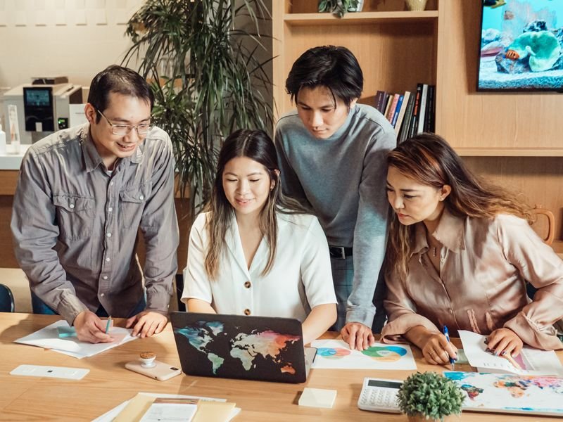 Team reviewing a laptop and charts in a bright meeting room