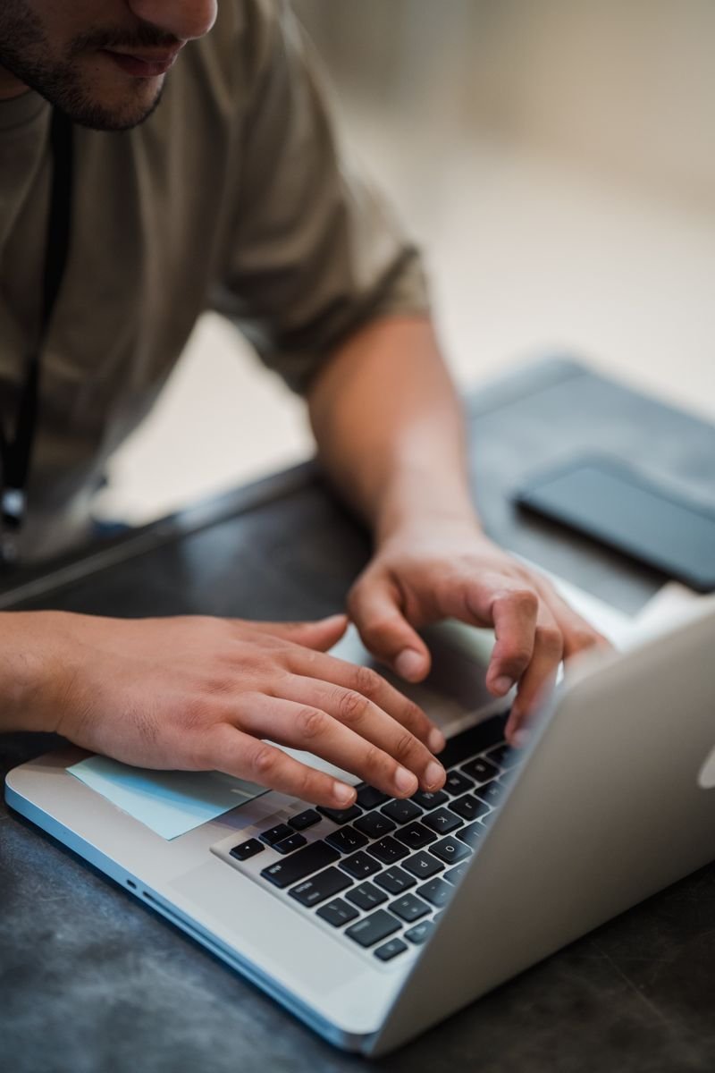 Close-up of hands typing on a laptop