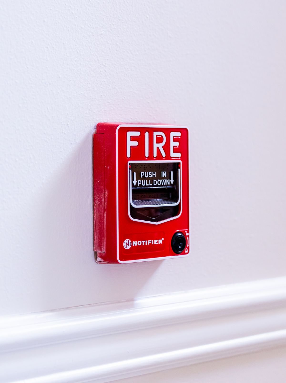 Red fire alarm switch on a wall